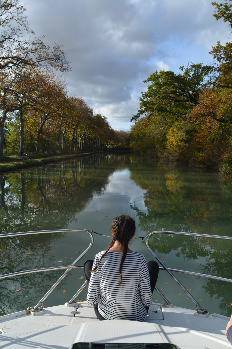 Blick auf ein Mädchen am Bug des Hausbootes und den Canal du Midi